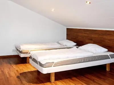 two beds in a room with wooden floors at 6 person holiday home in EIDSVÅG in Eidsvåg