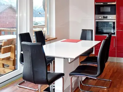a kitchen with a white table and black chairs at 6 person holiday home in EIDSVÅG in Eidsvåg