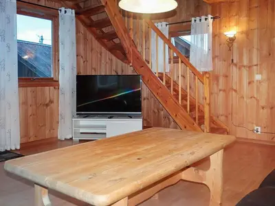 a living room with a wooden table and a television at 4 person holiday home in Måndalen in Sæbø