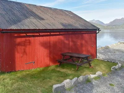 a picnic table sitting outside of a red building at 4 person holiday home in Måndalen in Sæbø