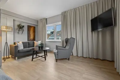 a living room with a couch and a chair and a table at Home Hotel Astoria in Hamar