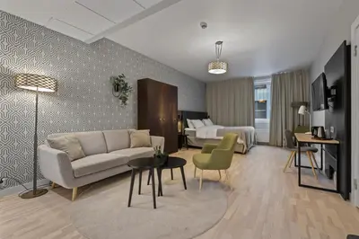 a living room with a couch and a bed at Home Hotel Astoria in Hamar