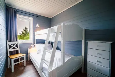 a bedroom with blue walls and a bunk bed at Hustadvika Havhotell - by Classic Norway Hotels in Farstad