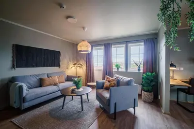a living room with a blue couch and a table at Hustadvika Havhotell - by Classic Norway Hotels in Farstad