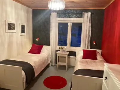 a bedroom with two beds with red pillows and a window at Nordbø Pensjonat in Hjartdal