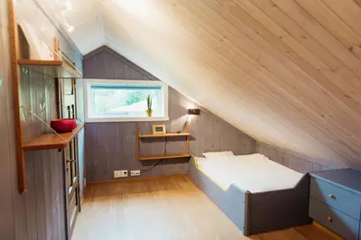 a small attic bedroom with a bed and a window at Ein heilt spesiell låve i Røldal in Røldal