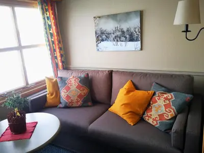 a couch with pillows on it in a living room at Grotli Høyfjellshotell in Grotli