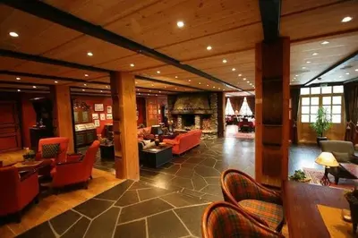 a lobby with orange chairs and a living room at Grotli Høyfjellshotell in Grotli