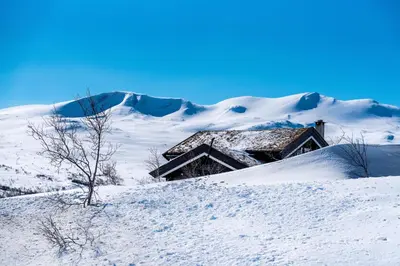 a house on top of a snow covered hill at Grotli Høyfjellshotell in Grotli