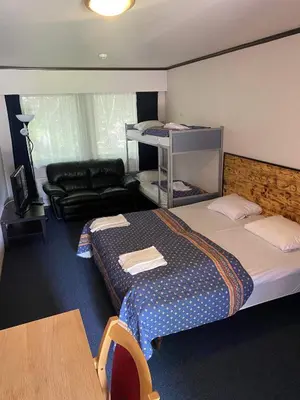 a hotel room with two beds and a couch at Sødorp Gjestgivergård Motell in Vinstra