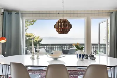 a dining room with a white table and chairs at Private House & Bungalow by the sea in Trondheim