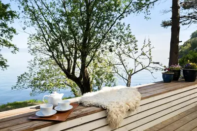 a table with cups and saucers on a deck at Private House & Bungalow by the sea in Trondheim