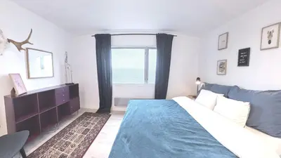 a bedroom with a bed and a large window at Private House & Bungalow by the sea in Trondheim
