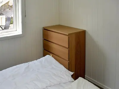 a bedroom with a bed and a dresser and a window at 8 person holiday home in Urangsvåg-By Traum in Ervik