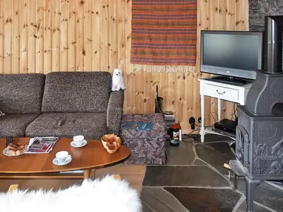 a living room with a couch and a stove at 6 person holiday home in Rennebu-By Traum in Sundset