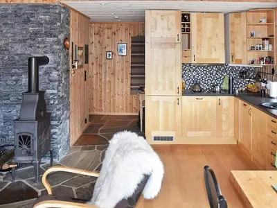 a white dog sitting in a kitchen with a stove at 6 person holiday home in Rennebu-By Traum in Sundset