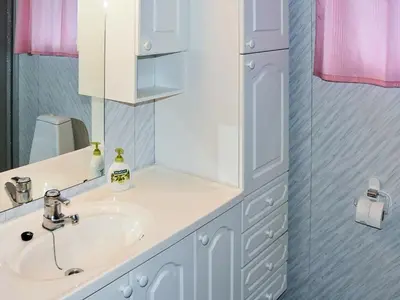 a white bathroom with a sink and a mirror at 8 person holiday home in VÅGLAND-By Traum in Vågland