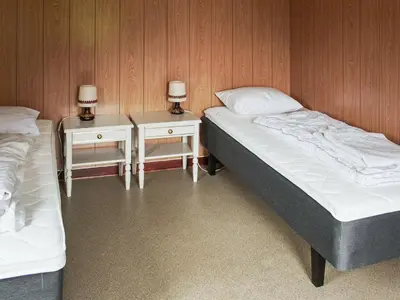 two beds in a room with two tables and two lamps at 8 person holiday home in VÅGLAND-By Traum in Vågland