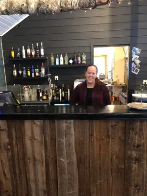 a woman sitting at a counter in a bar at Skysstasjonen Cottages in Røldal