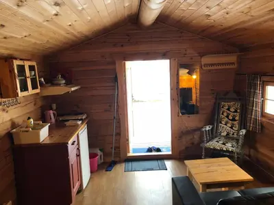 a kitchen and living room in a log cabin at Skysstasjonen Cottages in Røldal