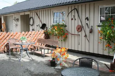a patio with a table and chairs and a building at Vertshuset Fannarheimr - Bed &Breakfast in Fannrem