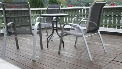 a group of chairs and a table on a deck at Vertshuset Fannarheimr - Bed &Breakfast in Fannrem