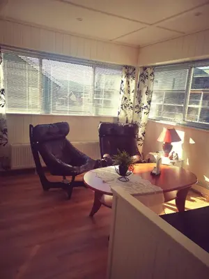 a living room with two chairs and a table at Vertshuset Fannarheimr - Bed &Breakfast in Fannrem