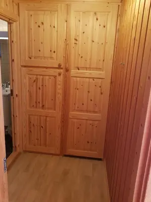 a room with wooden walls and two doors at Solstua Three-bedroom Cottage in Geilo