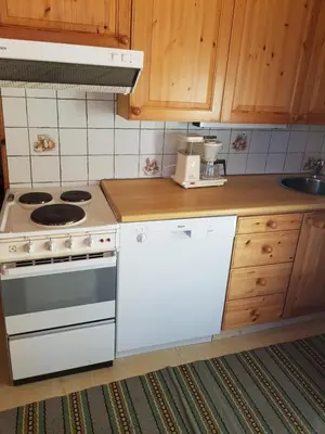 a kitchen with a white stove and a sink at Solstua Three-bedroom Cottage in Geilo