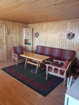 a living room with a couch and a wooden table at Nybu Two-bedroom cottage in Geilo