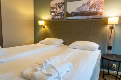 two beds in a hotel room with towels on them at Førde Hotel - Unike Hoteller in Førde