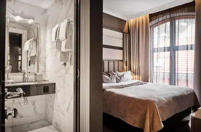 a hotel room with a bed and a bathroom at Opus 16, a Member of Small Luxury Hotels in Bergen