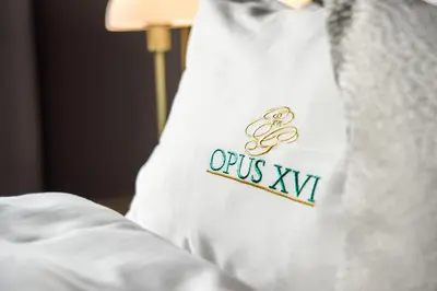 a white shirt with an ots xi on a bed at Opus 16, a Member of Small Luxury Hotels in Bergen