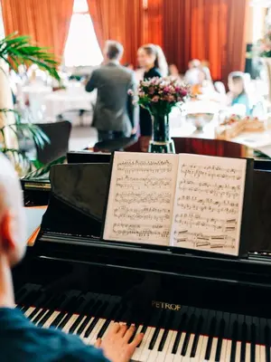 a man playing a piano in a restaurant at Opus 16, a Member of Small Luxury Hotels in Bergen