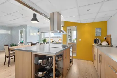 a kitchen with yellow walls and a kitchen island at Brekstad Gjestehus AS in Brekstad
