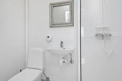 a bathroom with a sink and a toilet and a mirror at Brekstad Gjestehus AS in Brekstad