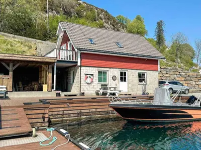a boat in the water in front of a house at 4 person holiday home in Urangsvåg-By Traum in Ervik