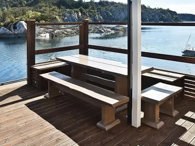 a wooden deck with a table and benches on the water at 8 person holiday home in Urangsvåg-By Traum in Ervik