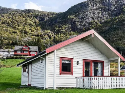 a white house with red windows and a mountain at 5 person holiday home in Selje-By Traum in Selje