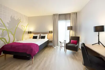 a hotel room with a bed and a chair at Thon Hotel Elgstua in Elverum