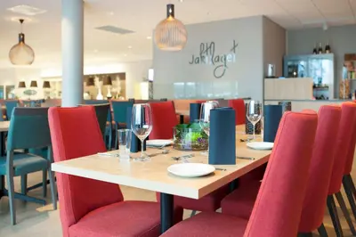 a table in a restaurant with red chairs at Thon Hotel Elgstua in Elverum