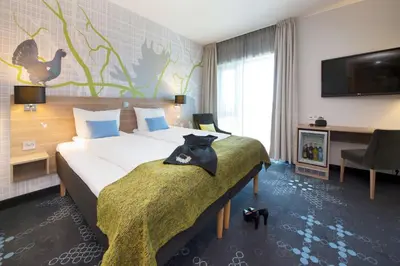 a hotel room with a bed with a cat on it at Thon Hotel Elgstua in Elverum