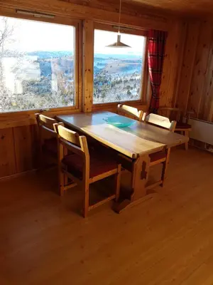 a dining room with a wooden table and chairs at Fjellbu Two-bedroom Cottage in Geilo