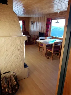a room with a table and a dining room at Fjellbu Two-bedroom Cottage in Geilo