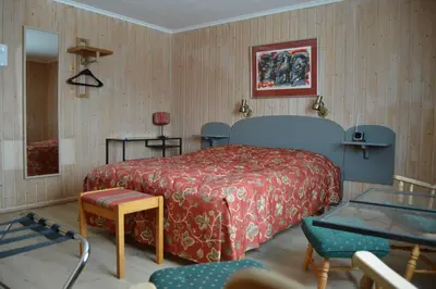 a bedroom with a bed and a table and chairs at Høvringen Fjellstue in Høvringen