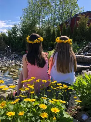 two girls sitting next to a pond with flowers at Orkla Camping in Orkanger