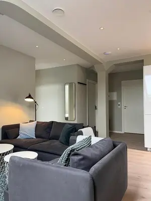 a living room with a couch and tables in it at Kong Oscars Apartments in Bergen