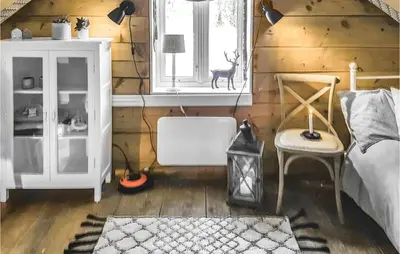 a bedroom with wooden walls and a bed and a window at 3 Bedroom Lovely Home In Vikanes in Eiknes
