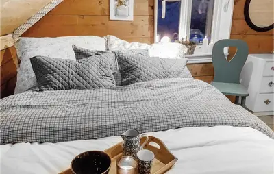 a bed with a wooden tray on top of it at 3 Bedroom Lovely Home In Vikanes in Eiknes