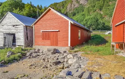 an orange and white building with rocks in front of it at 3 Bedroom Lovely Home In Vikanes in Eiknes